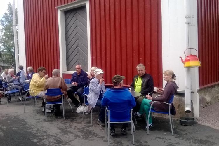 Ihmisiä kahvilla kellotapulin kupeessa.